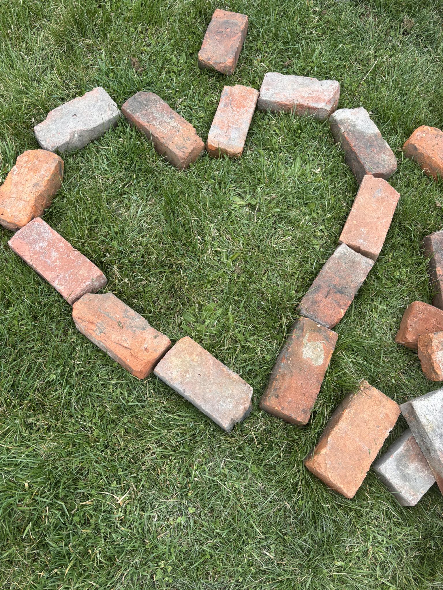 Bricks arranged in a heart shape on the grass at Hoosick Community Garden